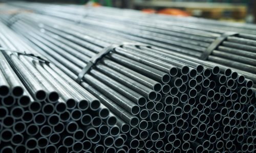 Industrial background of  black metal pipes ready for shipping in production workshop of metalworking plant, copy space